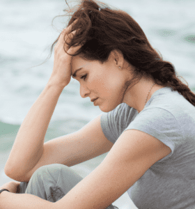 femme triste assise sur le bord de la plage