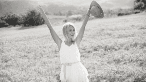 femme heureuse dans un champ avec une belle robe blanche