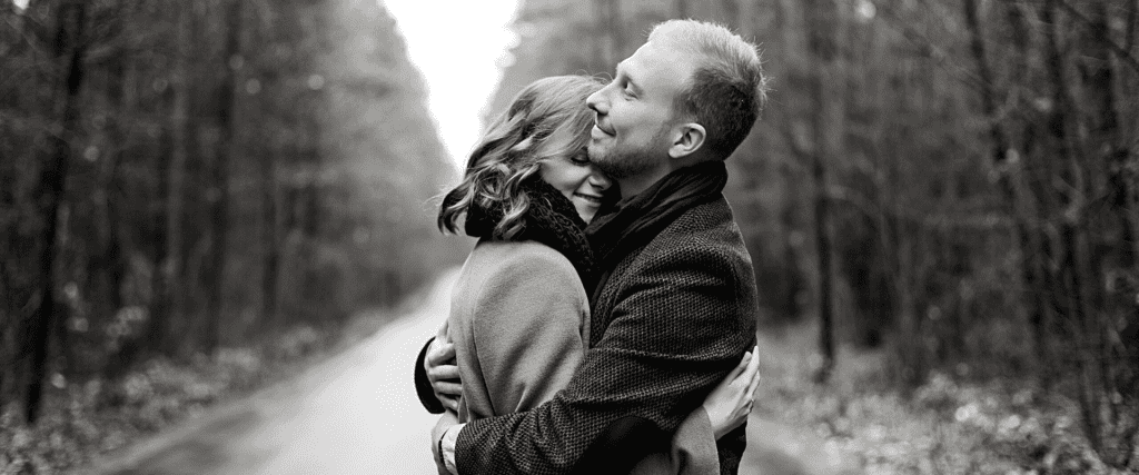 photo en noir et blanc d'un couple qui se tiennent dans les bras dans la rue