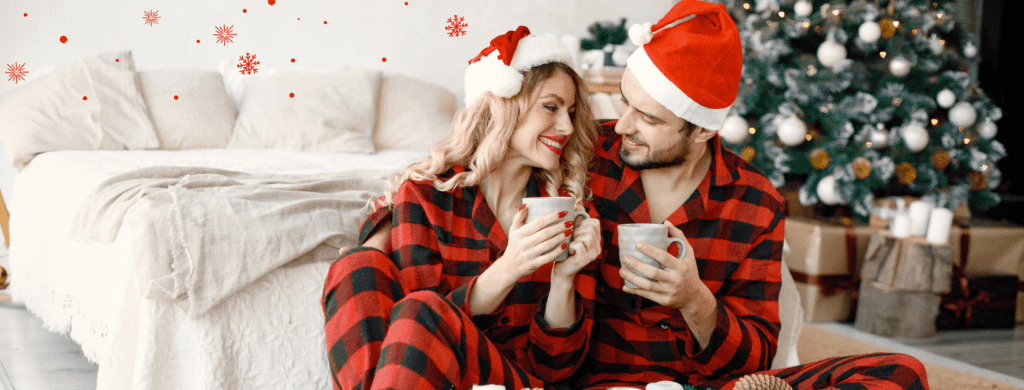 Un couple assis avec une tasse de café dans leur pyjamas de Noël